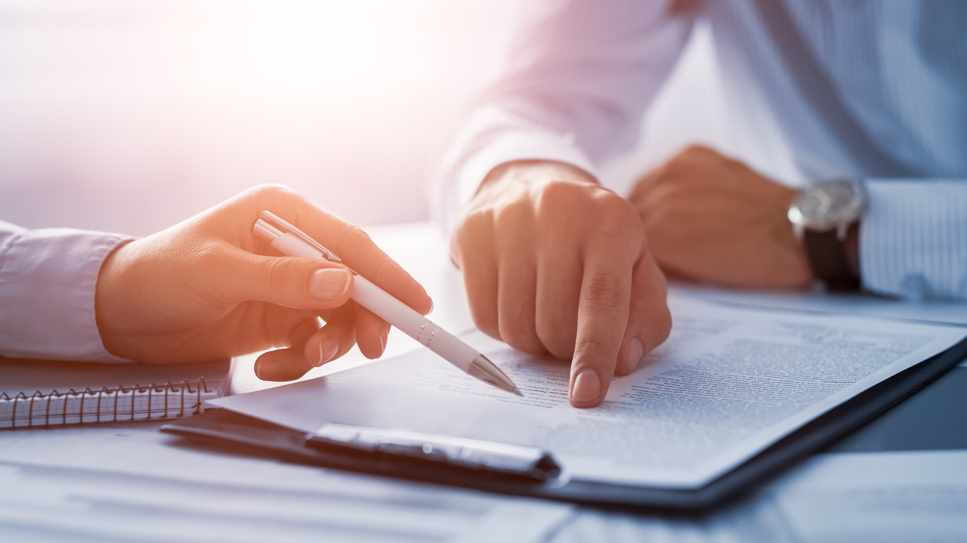Business people negotiating a contract. Human hands working with documents at desk and signing contract.